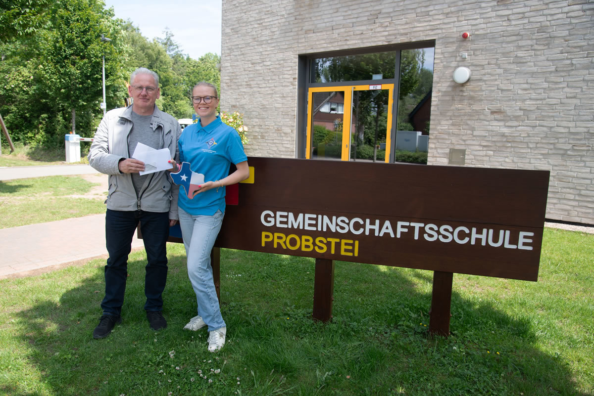 Für Maila-Sophie heißt es „auf nach Texas“<br /><br />Schönberg – „Texas, here I come“. Ende Juni, mit Beginn der Sommerferien bei uns, geht es los für Maila-Sophie Münstermann, 18, aus Hohenfelde. Als Gast des Jugendprogramms von Lions International darf sie für die Ferien zu einer Familie nach Midland in Texas in die USA fliegen. Initiator der Aktion im Rahmen seiner Jugendarbeit ist der Lions Club Wagrien aus Schönberg. Er hatte sich mit der Idee an die Gemeinschaftsschule Probstei gewandt, die ihre Schüler aufforderte, sich für das Projekt zu bewerben. Letztlich war es eben Maila-Sophie, die den Zuschlag dafür erhielt. Lions-Präsident Michael Rehfuß überreichte ihr nun offiziell die Flugunterlagen – passend verpackt in einer stilechten Texas-Dose, die der Fahne des amerikanischen Nationalstaates nachgebildet war.<br /><br />„Ich bin mehr als aufgeregt“, bekennt Maila-Sophie und trägt stolz das ihr von Lions International dafür extra zugesandte T-Shirt. „Ich gehe mit zwei anderen Schülern aus der Mongolei und Italien jeweils zu einer Familie nach Midland in Texas“. Was sie dort erwartet, weiss sie noch nicht genau, aber einen ersten schriftlichen Austausch mit ihren Gasteltern dort hatte sie schon per Internet. Deren Tochter machte solch eine Reise schon im Lions-Programm 2014 nach Italien. „Fest steht, dass uns wohl ein volles Programm erwartet“, sagt Maila-Sophie. Ziel sei es, die Kulturen der anderen Teilnehmer des Austausches kennenzulernen wie auch der Bevölkerung in Texas. <br /><br />Begleitet von den Gastfamilien sind gemeinsame Fahrten in die größten Städte in Texas geplant. Zum Beispiel Abilene und San Angelo, die siebengrößte Stadt der USA. Mit dabei ein Wochenende am See Brownwood und ein Trip nach Fort Worth/Dallas inklusive eines Rodeos. Aber auch einige Sozialeinrichtungen werden besucht. „Der Höhepunkt wird wohl das Feuerwerk und die Feierlichkeiten mit der Parade zum Unabhängigkeitstag der USA am 4. Juli sein“, so Maila-Sophie. Und, und, und -  auf dem Programm stehen noch Konzertbesuche, Soccer und Baseball-Spiele und lokale Sehenswürdigkeiten.<br /><br />In jedem Fall kommt da noch Einiges auf Maila-Sophie selbst zu: Vor dem örtlichen Lions Club soll sie einen Vortrag über ihre Heimat halten und ein „traditionelles Gericht kochen“. „Wir haben uns darauf verständigt, dass ich Currywurst mit Pommes mache, das kennt man dort gar nicht“, lacht Maila-Sophie. Ungewohnt für sie und die anderen Jugendlichen des Lions Programms wird allerdings das Wetter sein. „Derzeit gibt es dort nur Sonne und Temperaturen bis 40 Grad, hat man uns schon vorgewarnt“.<br /><br /> „Wir sind in jedem Fall mehr als glücklich, dass wir es als Lions Club der Probstei geschafft haben, jemanden in das Jugendprogramm von Lions International zu entsenden. Die Anzahl der deutschen Teilnehmer ist dabei sehr begrenzt“, so Lions Präsident Michael Rehfuß. Finanziert wird der Flug über den Lions Club Wagrien. Die Kosten in Amerika übernimmt der dortige Lions Club inklusive der Ausflüge. Für die Jugendlichen, die bisher an einer solchen Reise teilgenommen haben, war es immer ein Erfahrungsschatz, die sie nicht missen wollten. „Maila-Sophie hat uns in jedem Fall einen Erlebnisbericht mit vielen Bildern versprochen, zu dem wir dann auch Gäste einladen werden“, so Michael Rehfuss.